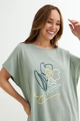 Vestido corto color verde oliva con estampado de dos rostros en color blanco.