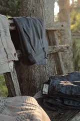 Pantalón de vestir color beige con estampado a cuadros en tonos marrones, verdes y rojos.