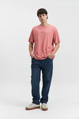 Remera de manga corta color salmón, con cuello redondo y logo pequeño estampado en el pecho.