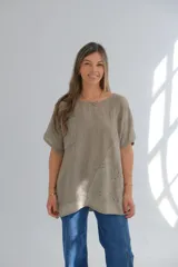 Blusa color visón de lino con mangas cortas, escote redondo y detalle de bordado calado en diagonal.
