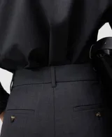 Pantalón de vestir gris melange, tiro alto, con pinzas frontales y pierna ancha y recta.