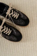 Championes acordonados color beige y dorado con suela marrón.