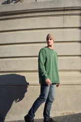 Buzo verde con cuello redondo y logo bordado en el pecho.