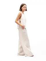 Musculosa blanca de lino con cuello redondo y laterales abiertos unidos por tres tiras cosidas.