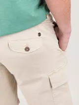 Bermuda color beige, corte regular fit, con cierre elástico y cordones en la cintura. Cuenta con bolsillos cargo laterales y detalles en los bolsillos.