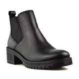 Bota Chelsea de cuero negro con elásticos laterales, caña baja, suela track y taco ancho.