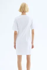 Vestido corto en punto de algodón suave con cuello redondo ribeteado acanalado, hombros caídos y mangas al codo. Pinzas moldeadoras en la parte posterior de la cintura para estilizar la figura.