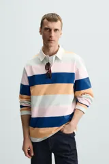 Polo de hombre de corte regular, con cuello solapa y cierre frontal de botonadura oculta por solapa, y manga larga. Diseño a rayas horizontales en azul marino, naranja, rosa y verde agua.