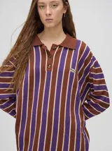 Chomba de algodón a rayas verticales color marrón, lila y blanco, de corte oversize con cuello camisero y puños en color marrón.