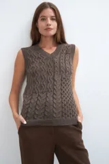 Chaleco tejido marrón con escote en v y sisas amplias. Diseño con diferentes puntos combinados en el frente.