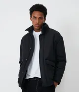 Campera puffer negra para hombre, con cuello alto, cierre frontal con botones a presión, bolsillos laterales y corte holgado. Fabricada en poliéster y poliamida.