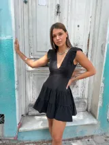 Vestido corto lila con escote en V, volados en los hombros y falda con dos niveles de volados.