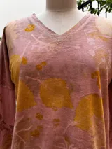 Remera rosa de manga larga con escote en V y estampado botánico.