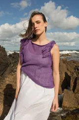 Musculosa tejida color marrón con diseño calado y flecos en los hombros.