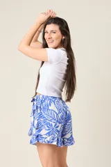 Short pollera con estampado de hojas azules y blancas, diseño cruzado, volados y lazo en la cintura.