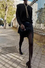 Minifalda azul petróleo de satén con encaje negro en el frente, corte al bies y cierre lateral invisible.