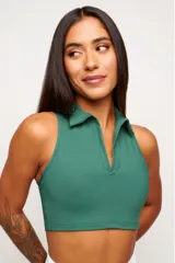 Top deportivo verde con cuello polo y cierre parcial con cremallera. Diseño sin mangas y corte crop.
