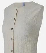 Blusa femenina de corte regular confeccionada en tejido de anarruga texturizado color beige. Presenta cuello redondo, diseño sin mangas y cierre frontal con botones.