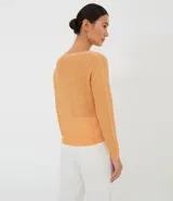 Blusa color naranja de tricot con cuello redondo y mangas largas.