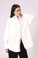 Camisa celeste de corte amplio, con cuello clásico, mangas largas y bolsillo en el pecho.