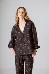 Camisa marrón con estampado de círculos blancos, cuello mao, manga larga y cierre frontal con botones.
