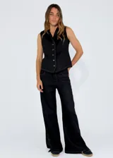 Chaleco beige de lino con escote en V, cierre frontal con botones y terminaciones desflecadas.