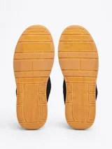 Zapatillas urbanas Tommy Jeans de corte bajo, color negro, confeccionadas en ante con interior de poliéster, entresuela texturizada color crema y suela de goma color caramelo. Presentan logo de la marca en el lateral y en la lengüeta.