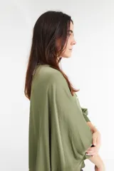 Camisa color beige de satén con corte holgado, cuello camisero y mangas largas con puños abotonados.