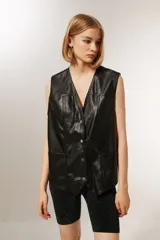 Chaleco negro de cuero sintético con cuello en V, sin mangas y corte holgado.