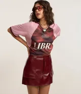 Short pollera de cuero sintético color bordó, con bolsillos delanteros con solapa y cierre frontal con cremallera.
