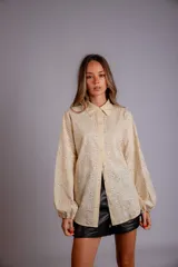 Camisa celeste con bordado de flores blancas, de manga larga abullonada.