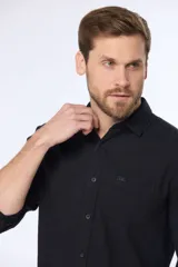 Camisa de lino color beige, de manga larga, con cuello clásico y bolsillo en el pecho.