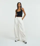 Blusa frente única color beige, con escote cuadrado y bretel ajustado en el cuello. Confeccionada en microfibra, es sin mangas y de corte ajustado.