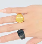 Anillo dorado unisex de acero quirúrgico hipoalergénico con forma de sello redondo.