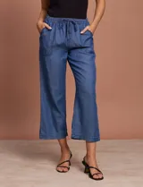 Pantalón capri de jean azul oscuro, con cintura elastizada con cordón ajustable y bolsillos laterales.