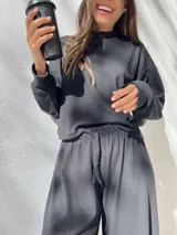 Conjunto negro de buzo y pantalón confeccionado en tela waffle de algodón. El buzo es de corte holgado y el pantalón es de corte recto.