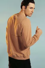Sweatshirt color marrón claro con cuello redondo y puños ajustados.