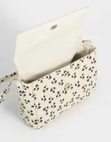 Bandolera color beige de cuerina con solapa, tag metálico y correa larga regulable.