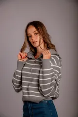 Sweater de punto color beige con rayas horizontales blancas, cuello polo con cierre de cremallera y mangas largas.