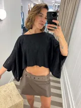 Minifalda cruzada de cuero color marrón topo, con detalle de textura de reptil en la pretina. Presenta cierres a presión en el lateral para ajuste.