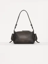 Bandolera azul de cuero vacuno con correa de hombro ajustable. Tiene cierre superior y bolsillos externos con cierre en el frente, dorso y laterales.