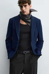 Blazer straight fit color gris claro confeccionada en tejido con viscosa. Cuello con solapas de muesca y manga larga acabada en puño con botón. Bolsillo de vivo en pecho y bolsillos de plastrón en cadera. Bajo con aberturas en espalda. Cierre frontal de botonadura.