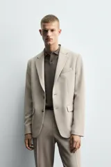 Blazer slim fit color beige confeccionada en tejido con viscosa. Cuello con solapas de muesca, manga larga acabada en puño con detalle de botones, bolsillo de vivo en pecho y de solapa en cadera, detalle bolsillo interior, bajo con aberturas en espalda y cierre frontal con botones.