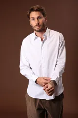 Camisa blanca de manga larga con cuello clásico y cierre frontal con botones.