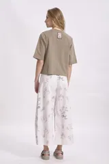 Pantalón palazzo de tiro alto con estampado de dibujos lineales en tonos pastel.