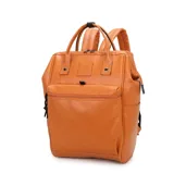 Mochila maternal marca Trendy confeccionada en cuero sintético color tostado. Presenta un compartimento principal con cierre, un bolsillo frontal con cremallera, bolsillos laterales y un bolsillo posterior de seguridad. Incluye asas superiores reforzadas y correas de hombro acolchadas ajustables.