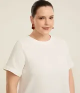 Blusa color beige de mangas cortas, cuello redondo con detalle de costuras y cierre trasero con botón.