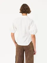 Camisa negra de popelina, de silueta amplia y diseño liviano. Incluye cuello clásico y cierre frontal con botones.
