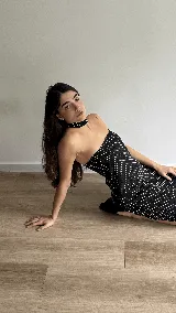 Vestido midi negro con lunares blancos, escote strapless y choker haciendo juego.
