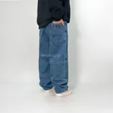 Pantalón de jean azul de corte ultra baggy con diseño de paneles y textura rústica.